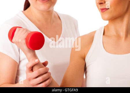 Physiotherapy - therapist doing arm  excercises with dumbbells for improving arm strenght and coordination  with a patient to re Stock Photo