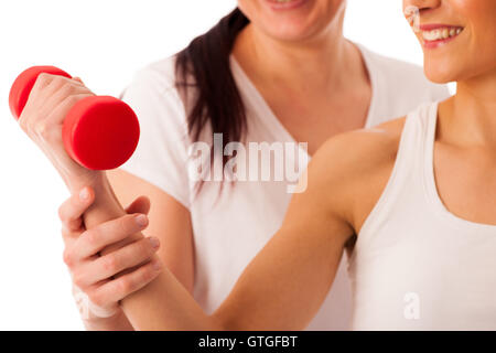 Physiotherapy - therapist doing arm  excercises with dumbbells for improving arm strenght and coordination  with a patient to re Stock Photo