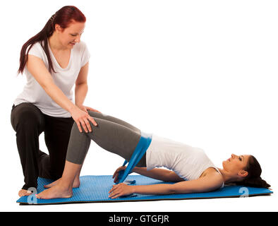Physiotherapy - therapist doing   excercises with band for improving back strenght and stability with a patient to recover  afte Stock Photo