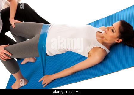 Physiotherapy - therapist doing   excercises with band for improving back strenght and stability with a patient to recover  afte Stock Photo