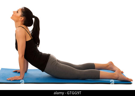 Young pretty woman doing yoga stretching exercises isolated over white background Stock Photo