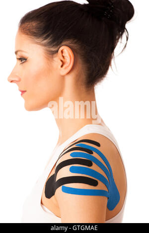 Beautiful young woman with kinesiotape on her shoulder to mobilise the area after injury Stock Photo