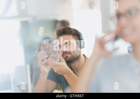 Businessman with headphones examining prototype Stock Photo