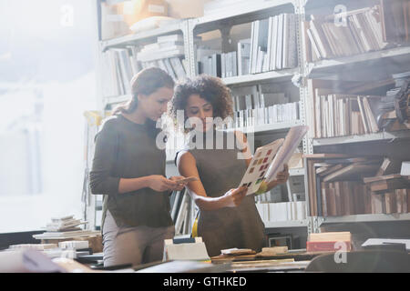 Female designers discussing paperwork in office Stock Photo