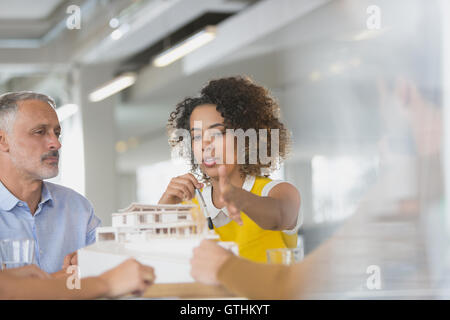 Architects discussing model in meeting Stock Photo