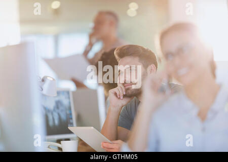 Pensive businessman using digital tablet in office Stock Photo