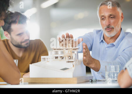 Architects discussing model in meeting Stock Photo