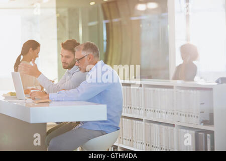 Businessmen working at laptop in office Stock Photo