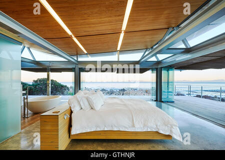 Modern luxury bedroom open to patio with ocean view Stock Photo