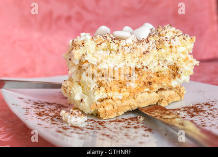 Meringue with cacao and white sugared almonds on white plate,photo close up. Stock Photo