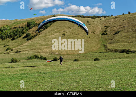 hang glider landing  in green field Stock Photo