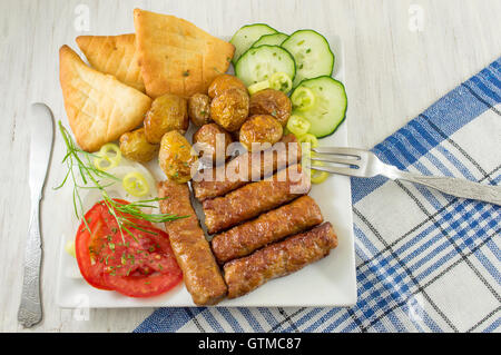 Barbecue on a plate with bread and vegetables Stock Photo