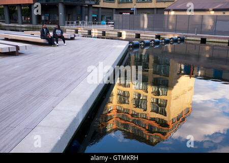 A nearby building reflected in the calm water of Paddington Basin, Floating Pocket Park, London, United Kingdom Stock Photo