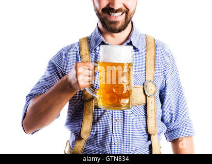 Unrecognizable man in bavarian clothes holding mug of beer Stock Photo