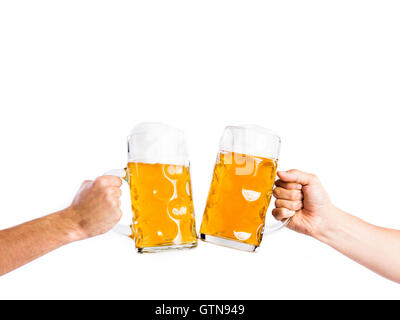 Two unrecognizable men clinking with beer mugs, studio shot Stock Photo