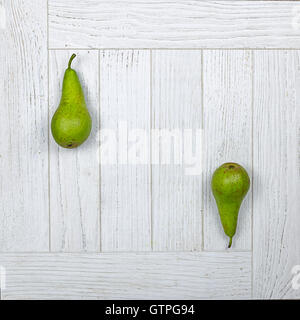 Two whole conference pears on a white wooden background Stock Photo