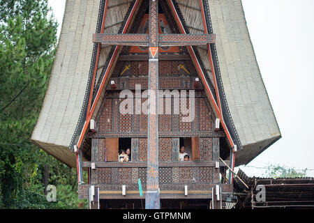 Toraja family pose for camera at the window of Toraja traditional house called Tongkonan at Bagan Pangala village. Stock Photo