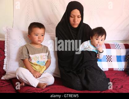Kabul, Afghanistan. 10th Sep, 2016. Photo taken on Sept. 10, 2016 shows Jamila and her two children at her home in Kabul, capital of Afghanistan. The impoverished mother of two, Jamila, who like many Afghans uses one name, had lost her husband in a suicide bombing in Kabul, lamented that life contrary to her expectations had been shattered due to continued insurgency and poverty. About 36 percent of Afghanistan's some 30 million population, according to officials, are currently living below the poverty line. Credit:  Rahmat Alizadah/Xinhua/Alamy Live News Stock Photo