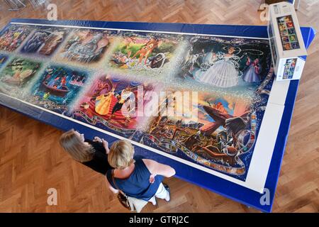 Ravensburg, Germany. 10th Sep, 2016. Two visitors look at the biggest series-produced puzzle worldwide, which has been almost completed within seven hours, in the historical Schworsaal in Ravensburg, Germany, 10 September 2016. Only one piece of the puzzle was missing, as the puzzlers realised at the end. The missing piece was replaced by one from a different world record puzzle. The puzzle consists of a total of 40320 pieces, is 6.8 metres wide and 1.9 metres high. PHOTO: FELIX KAESTLE/dpa/Ģ����ý Live News Stock Photo