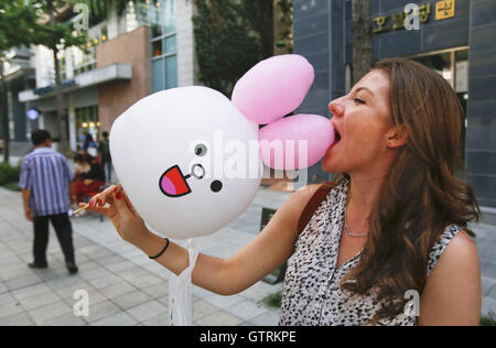 Seoul, South Korea. 11th Sep, 2016. A woman eats cotton candy in the shape of a rabbit. © Min Won-Ki/ZUMA Wire/Alamy Live News Stock Photo