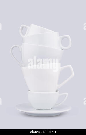 Front view of white ceramic coffee cups piled up on a dish on grey background Stock Photo
