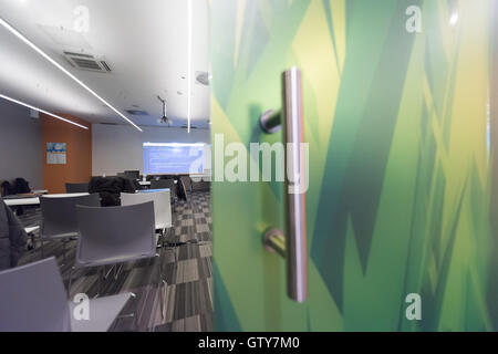 empty it classroom with program code on projector screen and modern laptop computers on table Stock Photo