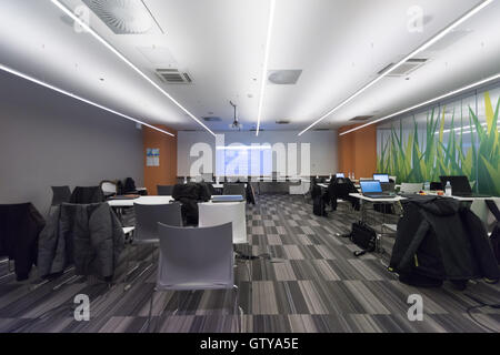 empty it classroom with program code on projector screen and modern laptop computers on table Stock Photo