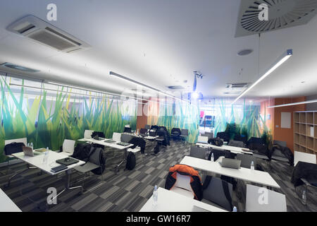 empty it classroom with program code on projector screen and modern laptop computers on table Stock Photo