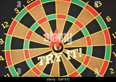 Text Try It written on the circular target with a plastic feather in the center Stock Photo