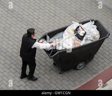 worker picking up trash and bags of garbage high angle overhead view Stock Photo