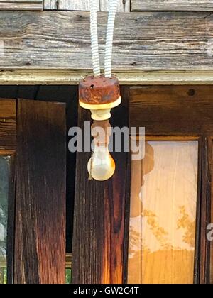 A  light hanging down in front of the doors on an old building. Stock Photo