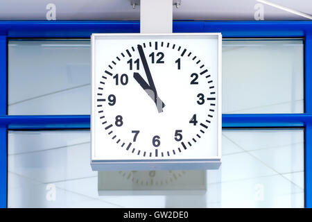 Square clock against glass office style wall with reflection. Time for work concept Stock Photo