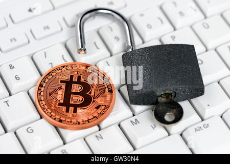 Bitcoin and open padlock on computer keyboard, virtual currency Stock Photo