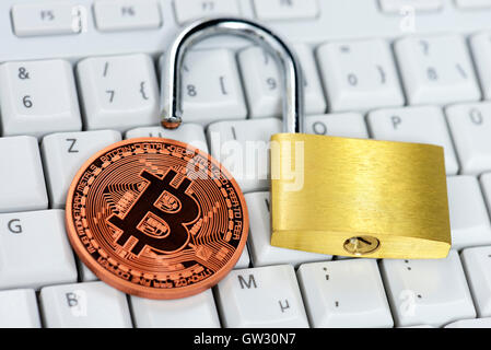 Bitcoin and open padlock on computer keyboard, virtual currency Stock Photo