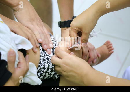 Children receiving vaccine at out side of the thigh.Children vaccine. Stock Photo