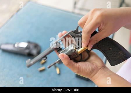people load bullets into revolver gun befor shooting Stock Photo