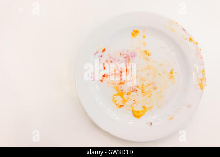 Empty white plate with crumbs and cream after eating Stock Photo
