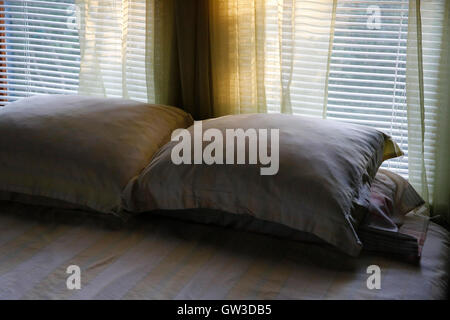 pillows on a bed late afternoon light filtering through the window Stock Photo