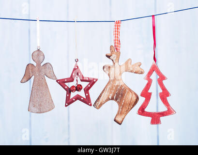 Old Christmas decorations hanging on string on blue background Stock Photo