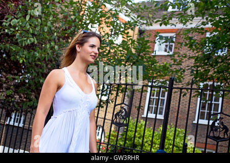 young woman walking in the street wearing a summer's dress Stock Photo