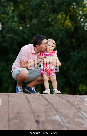 Dad with daughter on wooden bridge in park Stock Photo