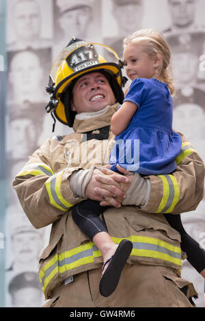 Kansas City, Missouri, USA. 11th Sep, 2016. Kansas City holds its annual 911 Memorial Stair Climb in remembrance of the 343 NYC firefighters who gave their lives September 11, 2001. Firefighters from across the Midwest participated in a 110-story climb up the Town Pavilion high-rise. The event is both a commemoration for 911 and a fund-raiser for S.A.F.E (Surviving Spouse and Family Endowment Fund). Pictured is Firefighter Mark Smith from Mission Township (near Topeka, KS) with his 5-year old daughter, Adele. Firefighter Smith represents the NYC firefighter Paul Tegtmeier from Engine 4. Stock Photo