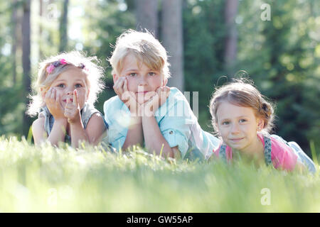 Little friends laying on grass in summer park Stock Photo