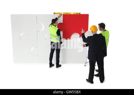 Team of business man and workers making business assmebling puzzle together isolated on white background Stock Photo