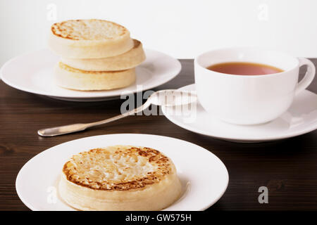 Tea and crumpets on a dark wooden table Stock Photo