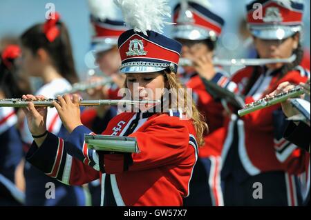 Marching band members playing during a halftime performance at a high school football game. USA. Stock Photo