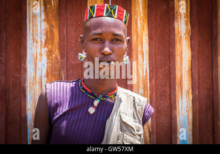 Young man of the Bana tribe of the Omo Valley of Southern Ethiopia in traditional garb with beaded hat, earrings and necklace Stock Photo