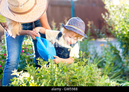 Child boy helps to mother working in the garden Stock Photo