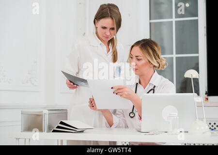 Doctor and nurse looking at docments in medical office Stock Photo