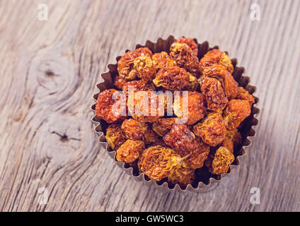 Physalis berries in a bowl on a wooden background Stock Photo